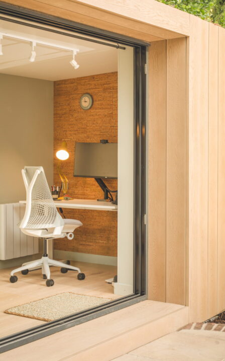 Looking in to Little Green Room in golden oak with desk setup inside.