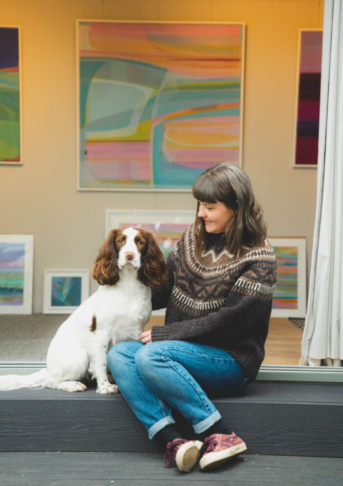 Delyth and her spaniel sat on the decking of her Little Green Room.